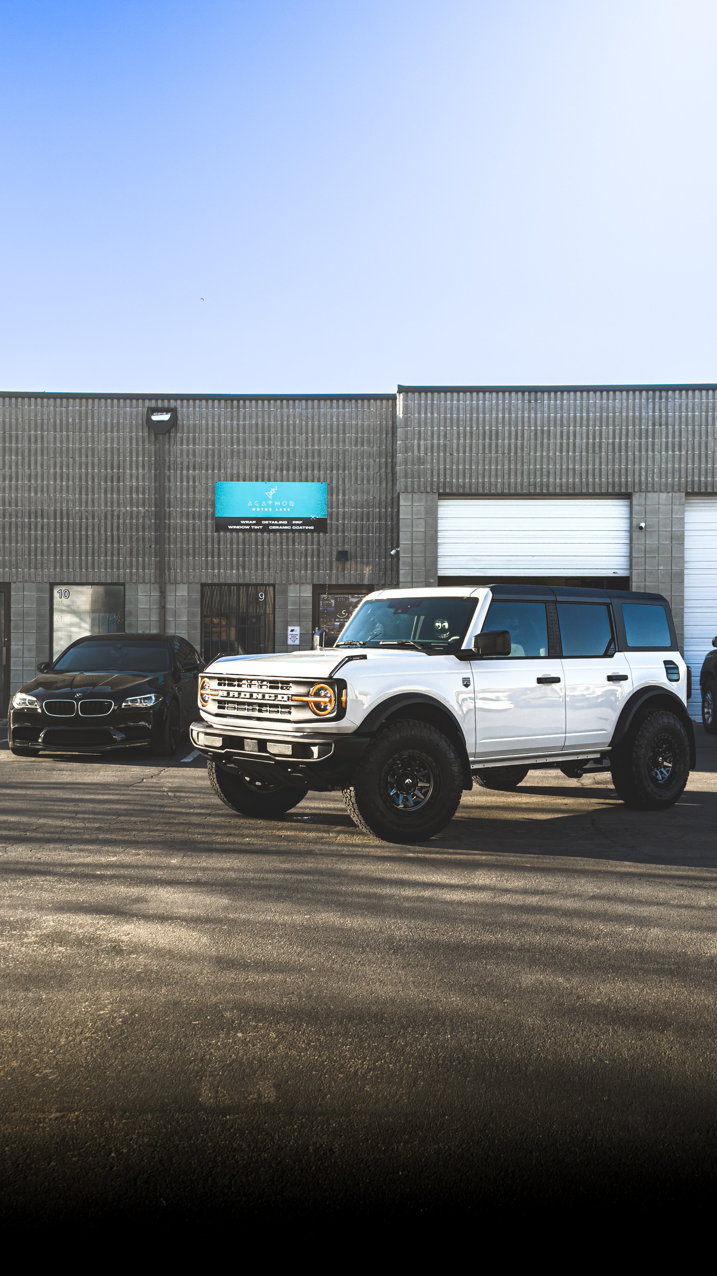 Agathos Motors Lab storefront with Bronco and BMW M5